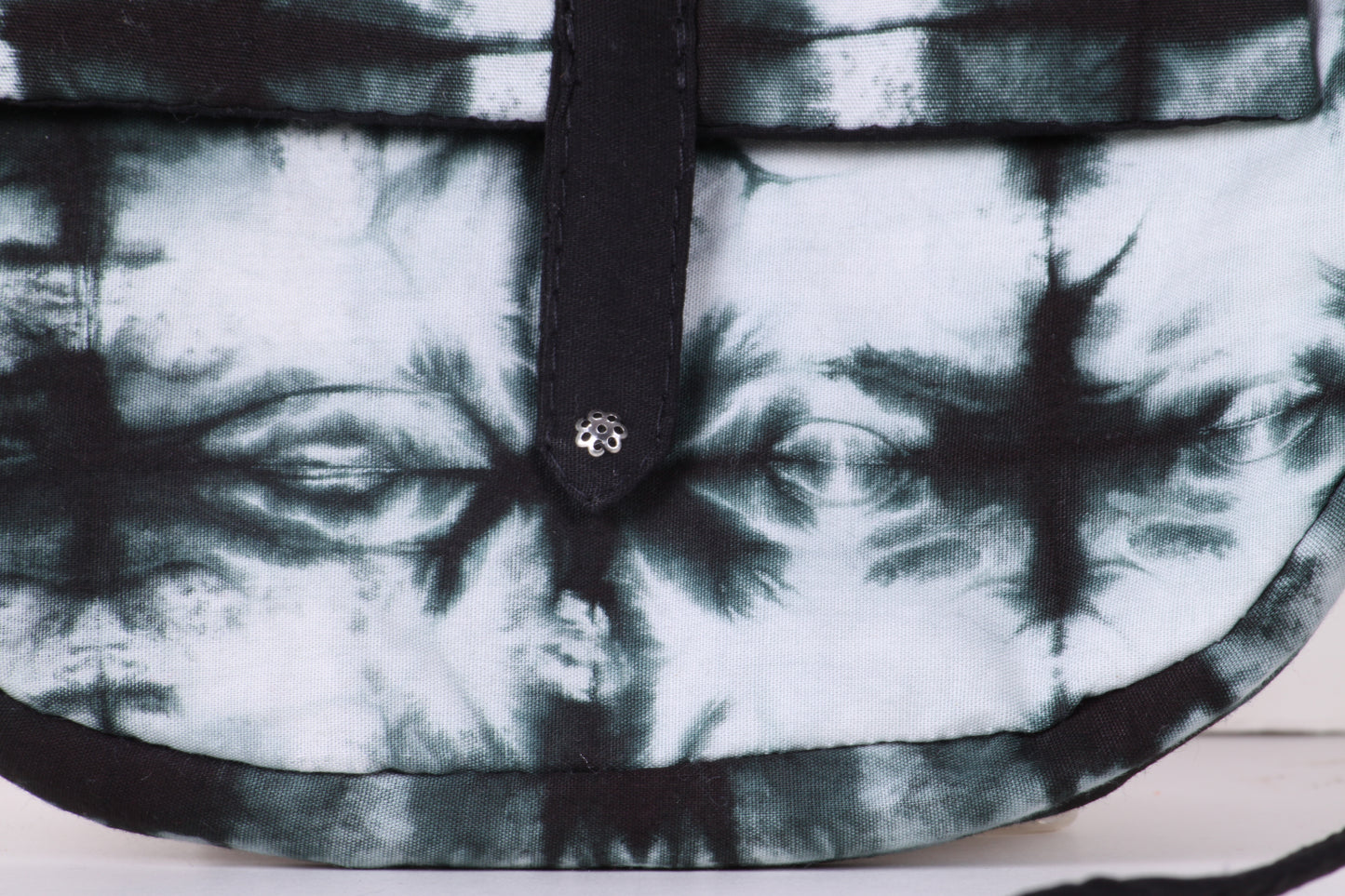 Closeup view of Black And White Check Sling Bag in cotton tie dye fabric with a magnetic snap closure and an interior pocket