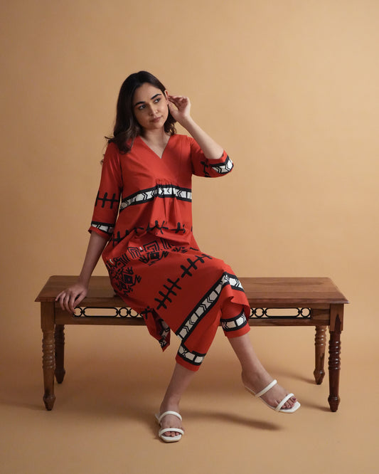 Model wearing Puka Cotton Co-ord Set in vibrant red with tribal prints, side-slit kurta, and slim pants