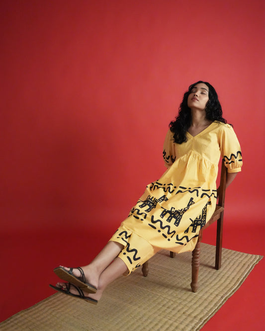 Side view of Sikwu Cotton Co-ord Set in mango yellow with puff sleeves, tribal prints, and bold wide-leg pants