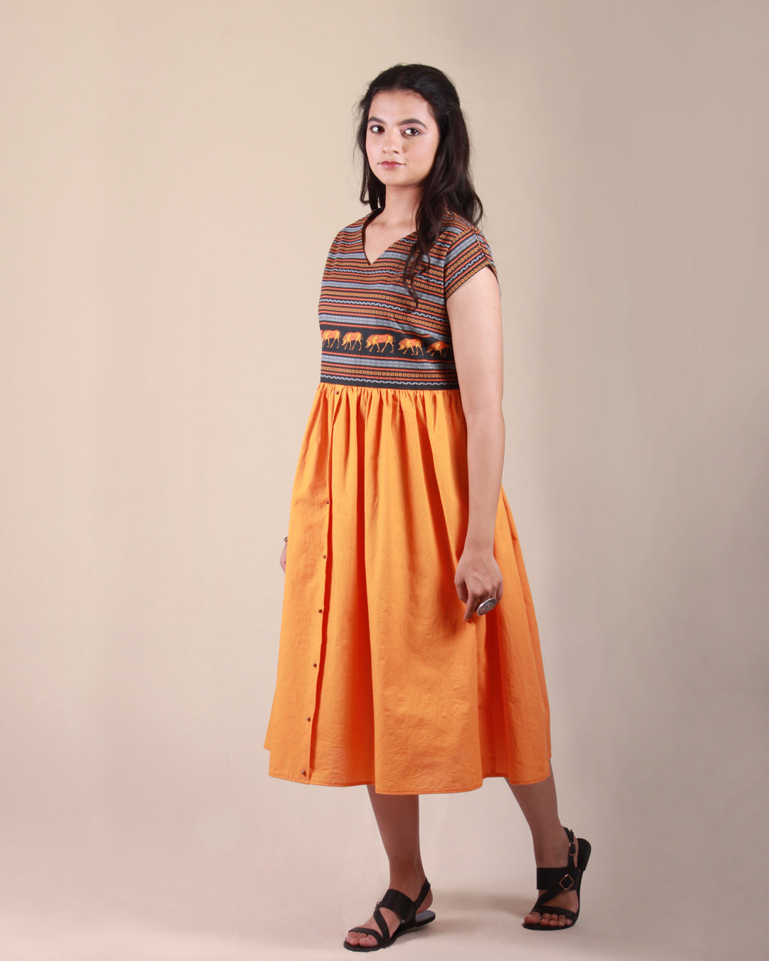 Full side front view of orange Amphora Pottery Dress in cotton fabric with printed yoke detail and cap sleeves