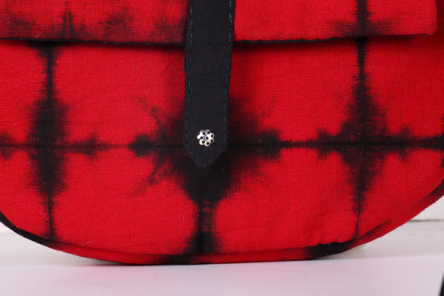 Closeup view of Red Check Sling Bag in cotton tie dye fabric with a magnetic snap closure and an interior pocket