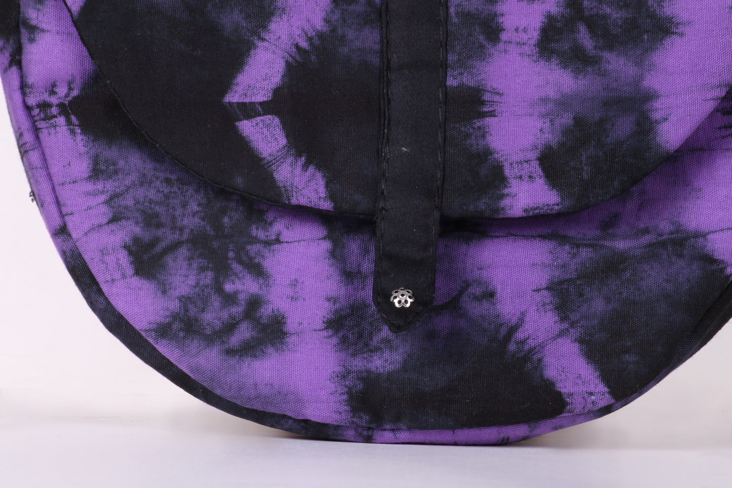 Closeup view of Violet Taco Sling Bag in cotton tie dye fabric with a magnetic snap closure and an interior pocket