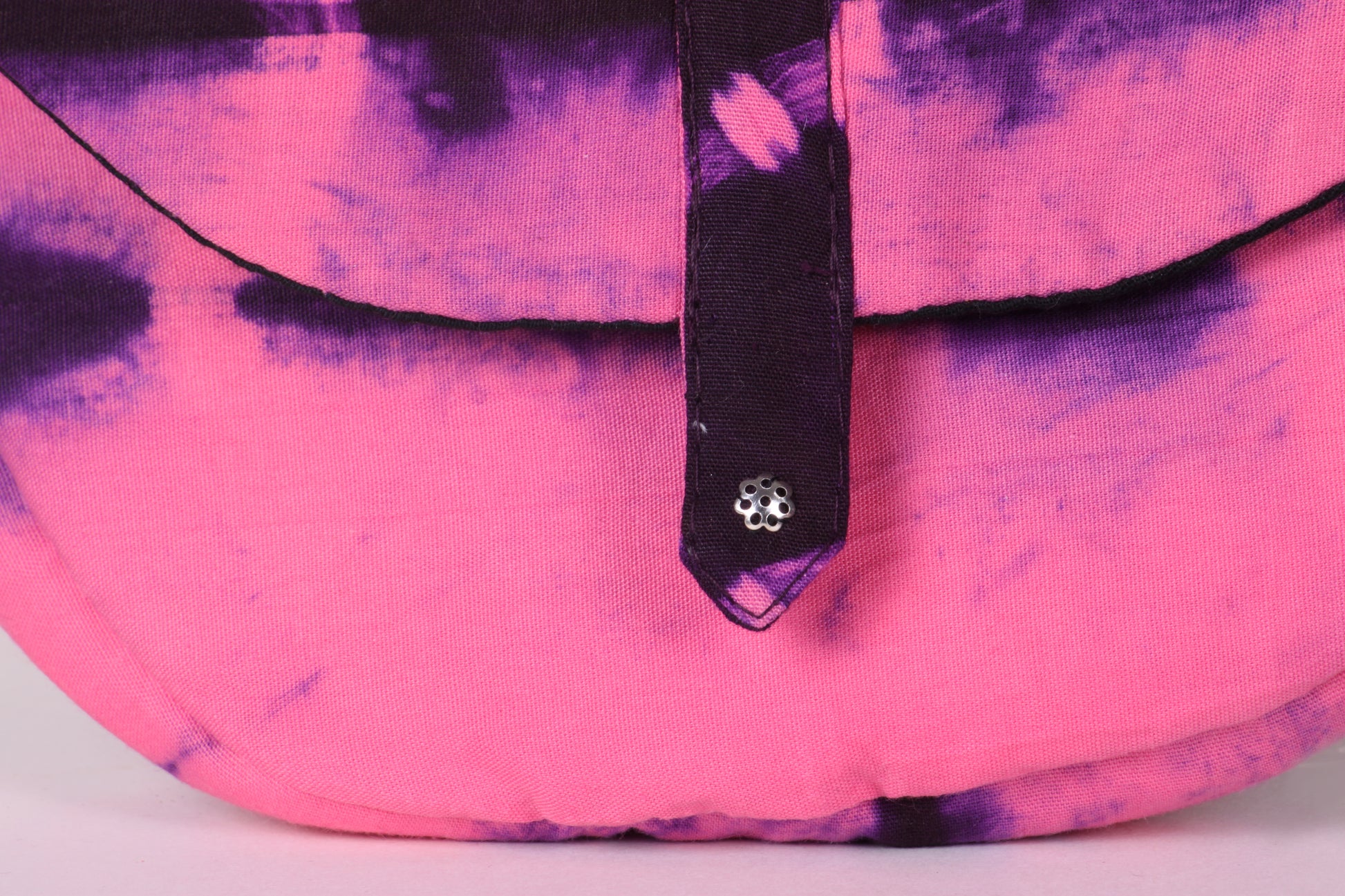 Closeup view of Pink Taco Sling Bag in cotton tie dye fabric with a magnetic snap closure and an interior pocket