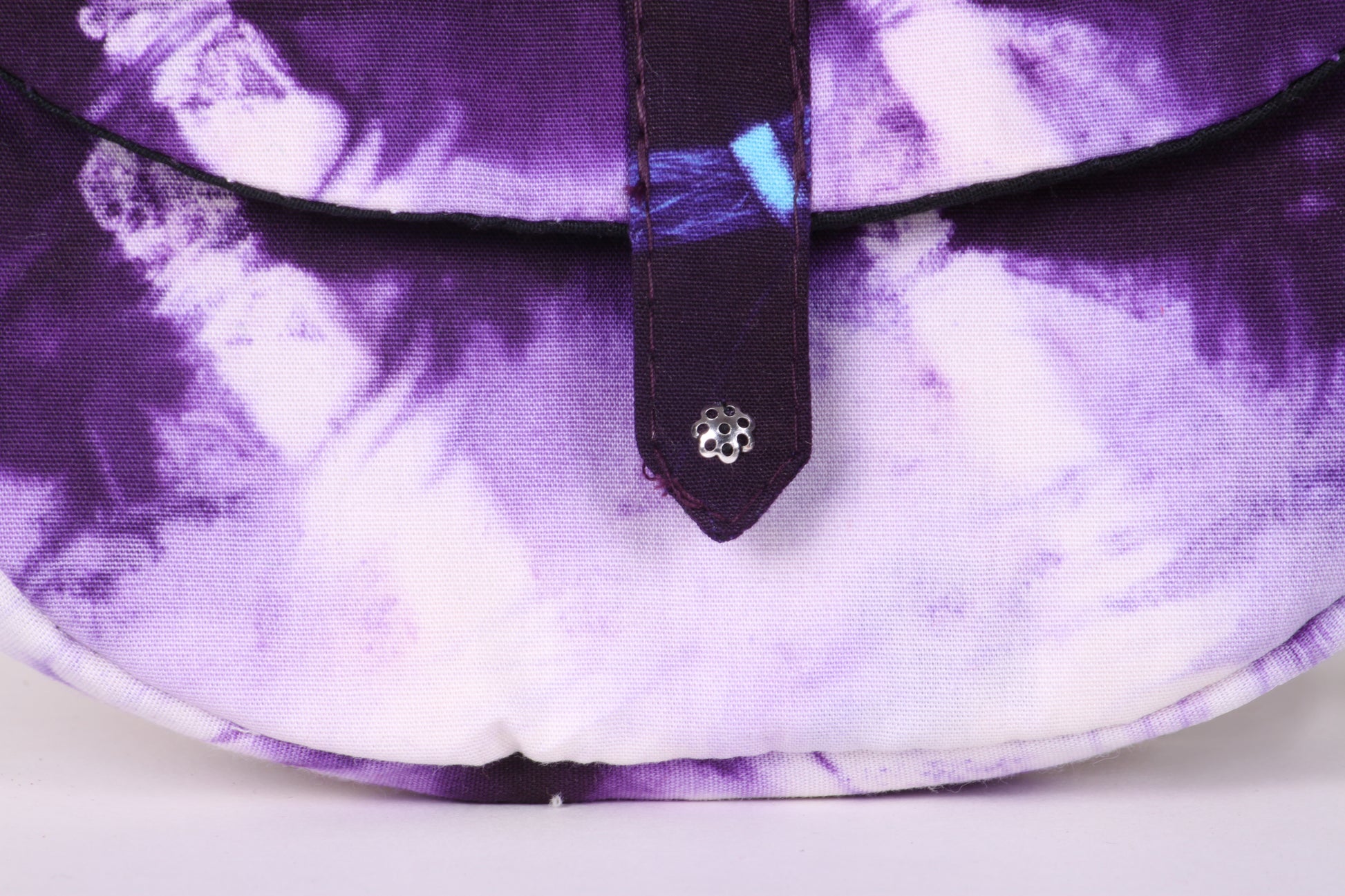 Closeup view of White Taco Sling Bag in cotton tie dye fabric with a magnetic snap closure and an interior pocket