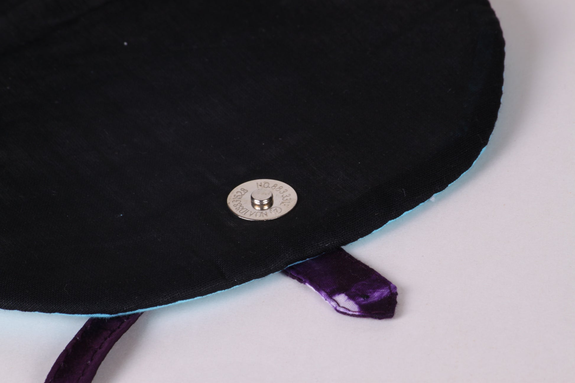  Interior button closeup of Violet Taco Sling Bag in cotton tie dye fabric