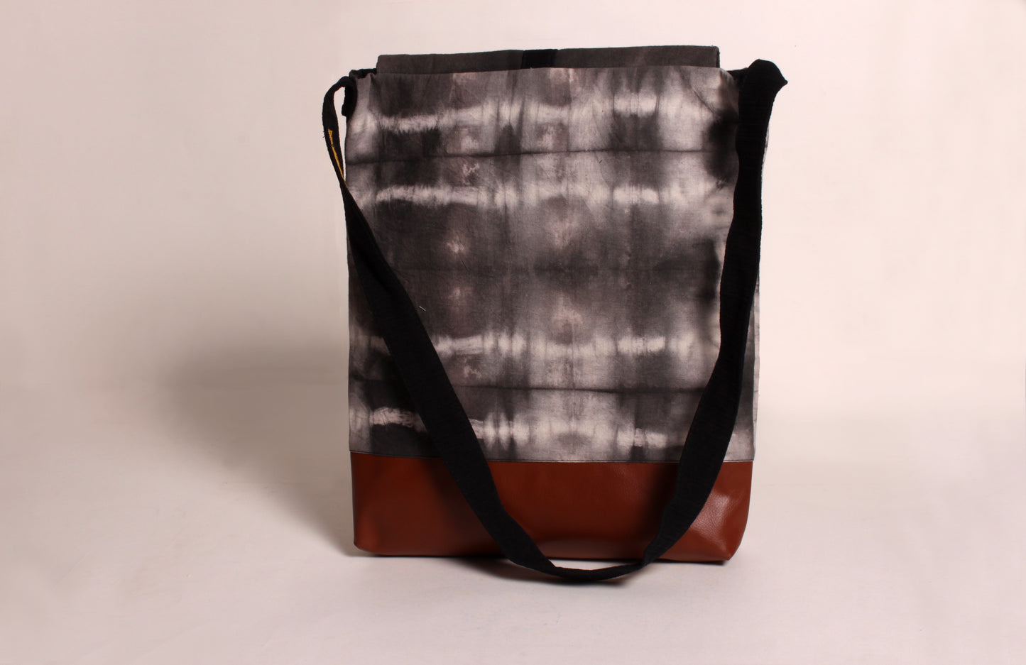 Back view of Stone Grey Artist Bag made from cotton fabric with faux leather, a magnetic snap closure, and a pocket 