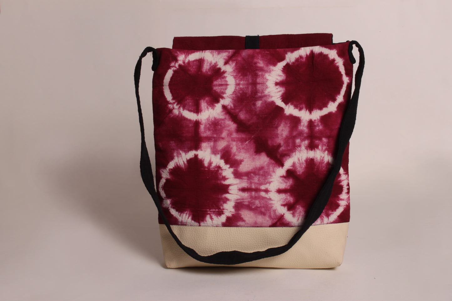 Back view of Maroon Flower Artist Bag made from cotton fabric with faux leather, a magnetic snap closure, and a pocket 