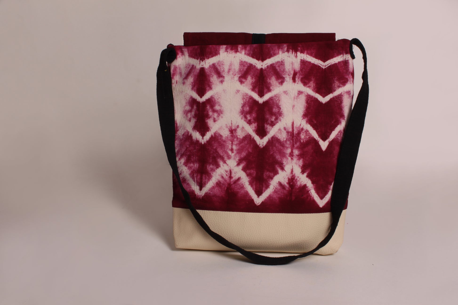 Back view of Maroon Wave Artist Bag made from cotton fabric with faux leather, a magnetic snap closure, and a pocket 