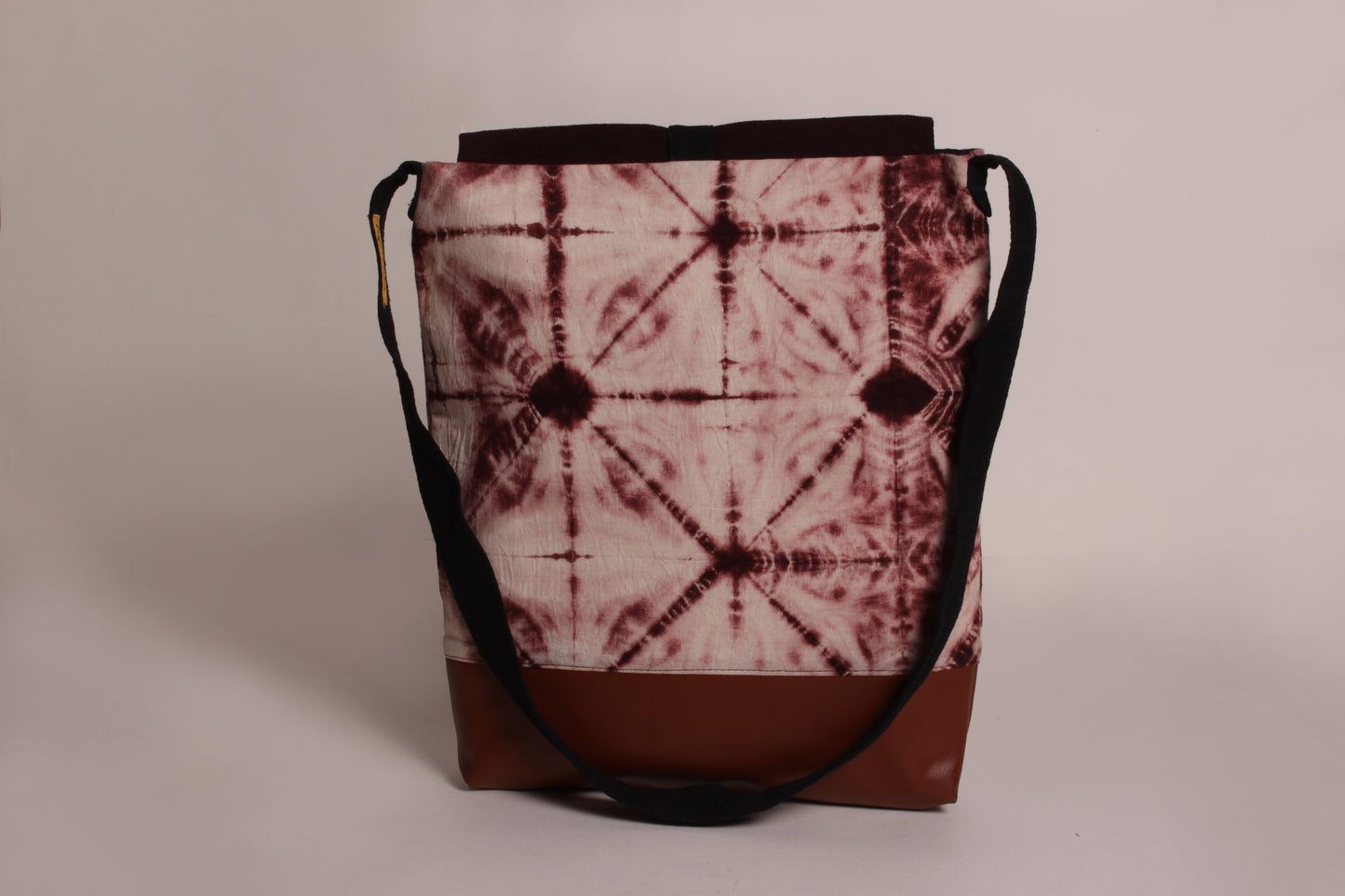 Back view of Brown Ripple Artist Bag made from cotton fabric with faux leather, a magnetic snap closure, and a pocket 