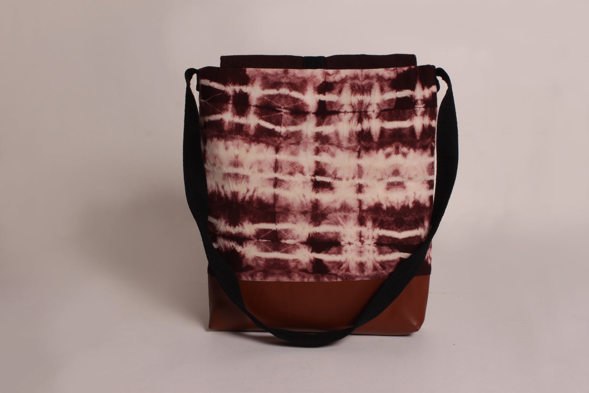 Back view of Earthy Brown Artist Bag made from cotton fabric with faux leather, a magnetic snap closure, and a pocket 