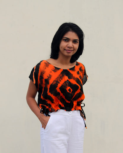 Front view of Tie Dye Orange Black Crop Top in cotton blend with drawstring detail at waist