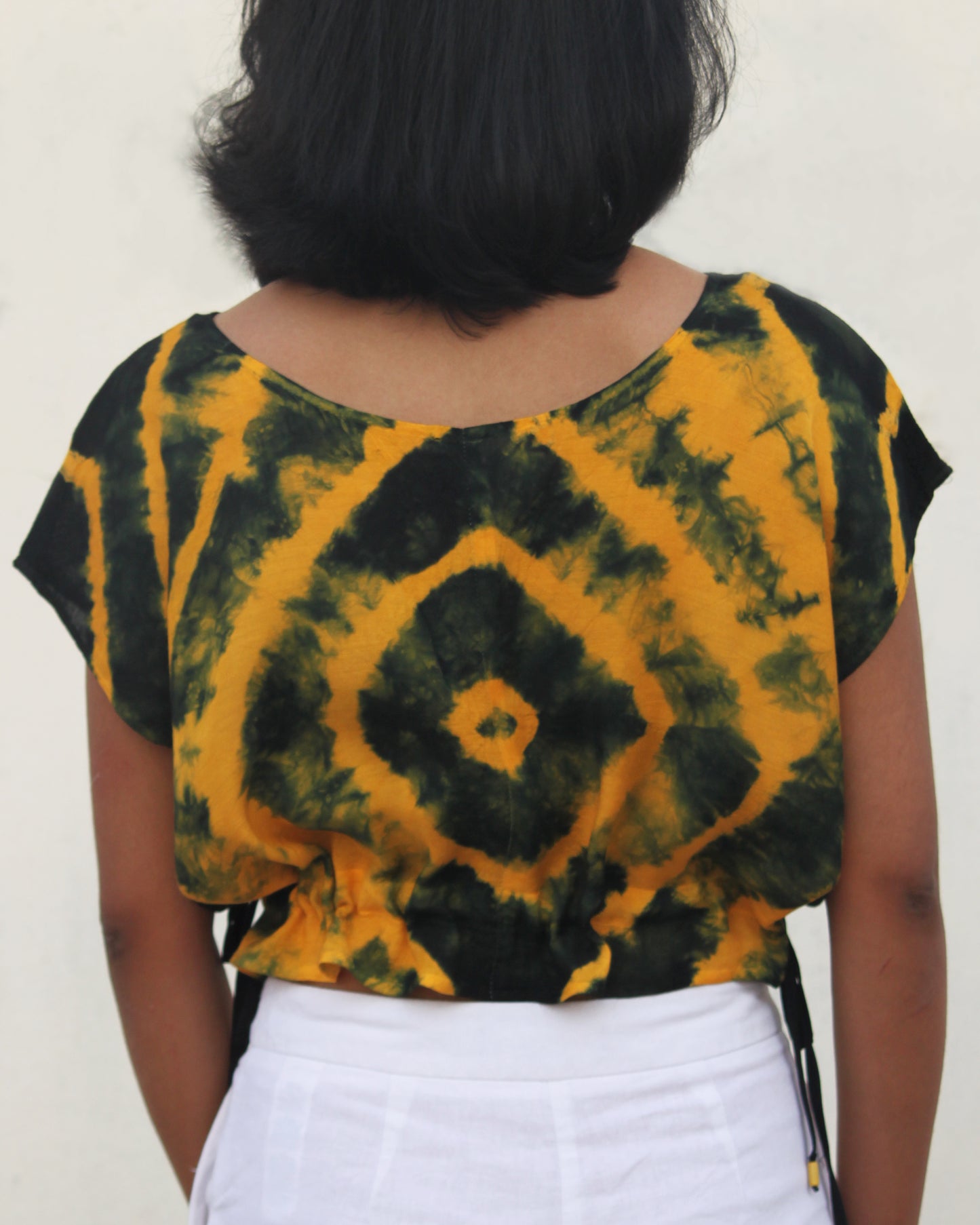 Back view of Tie Dye Yellow Black Crop Top in cotton blend with drawstring detail at waist