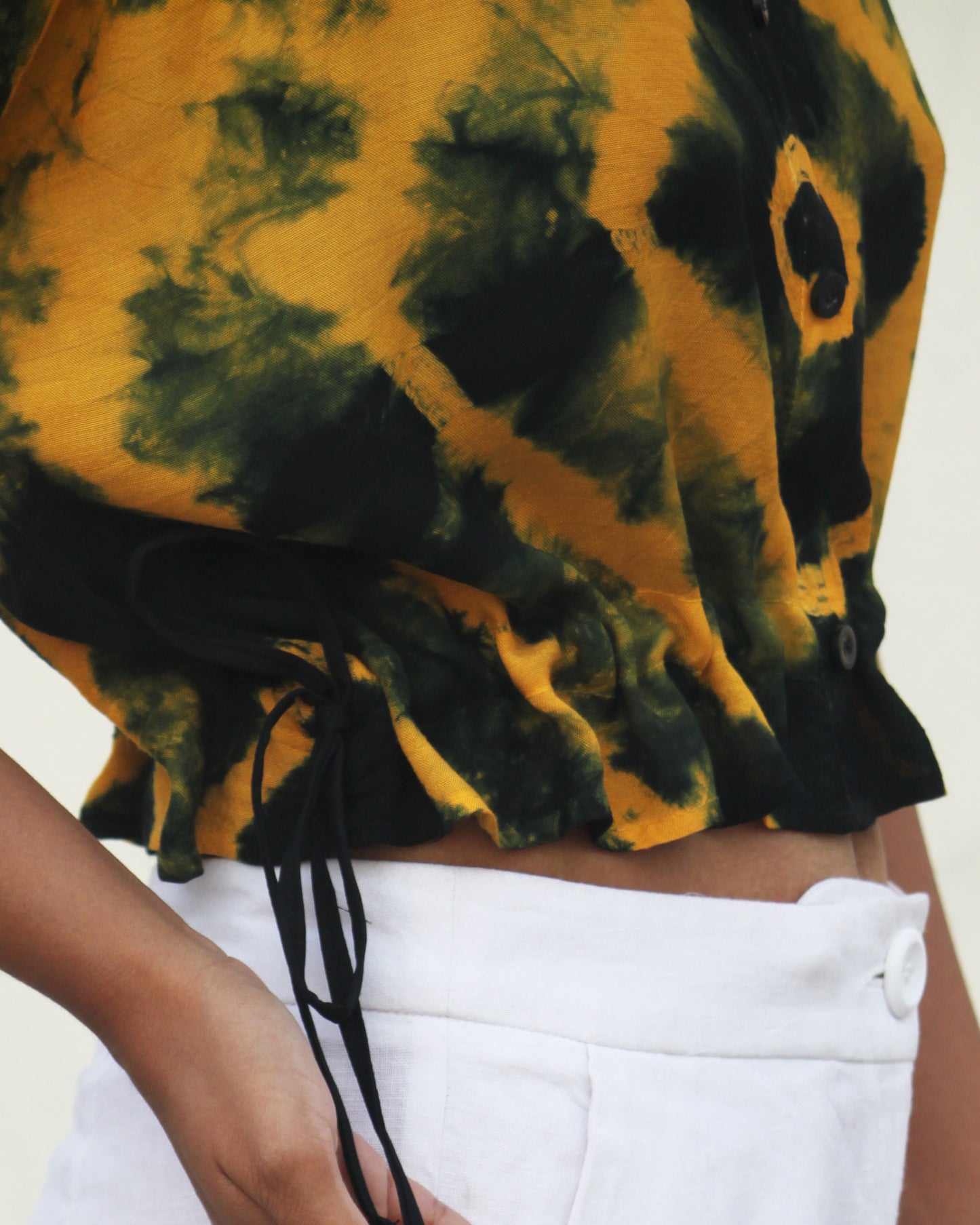 Side view of Tie Dye Yellow Black Crop Top in cotton blend with drawstring detail at waist