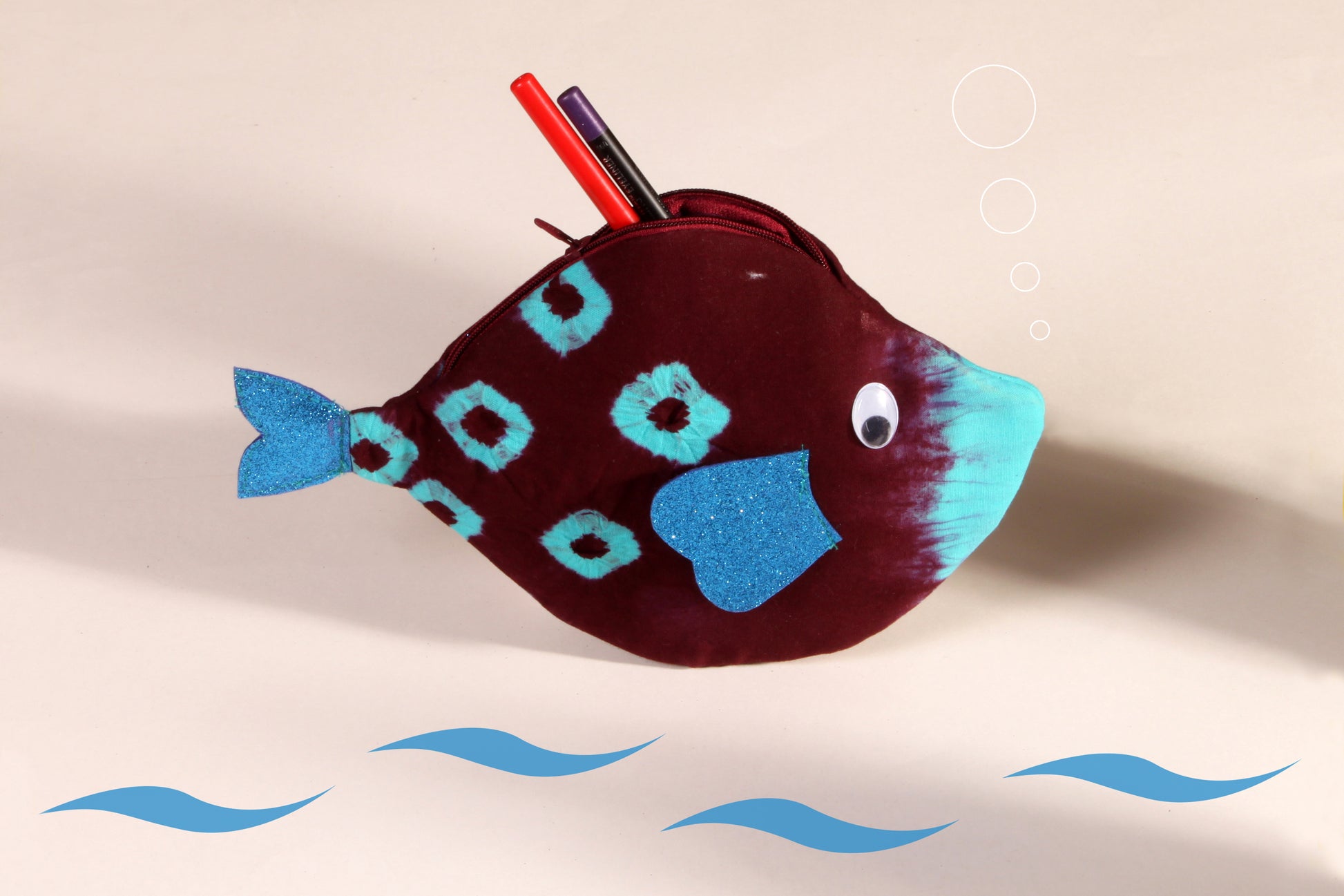 Side view of Maroon Pomfret Fish Pouch made from cotton fabric showing makeup organised 