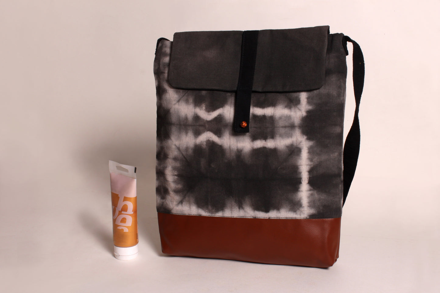 Front view of Stone Grey Artist Bag made from cotton fabric with faux leather, a magnetic snap closure, and a pocket 