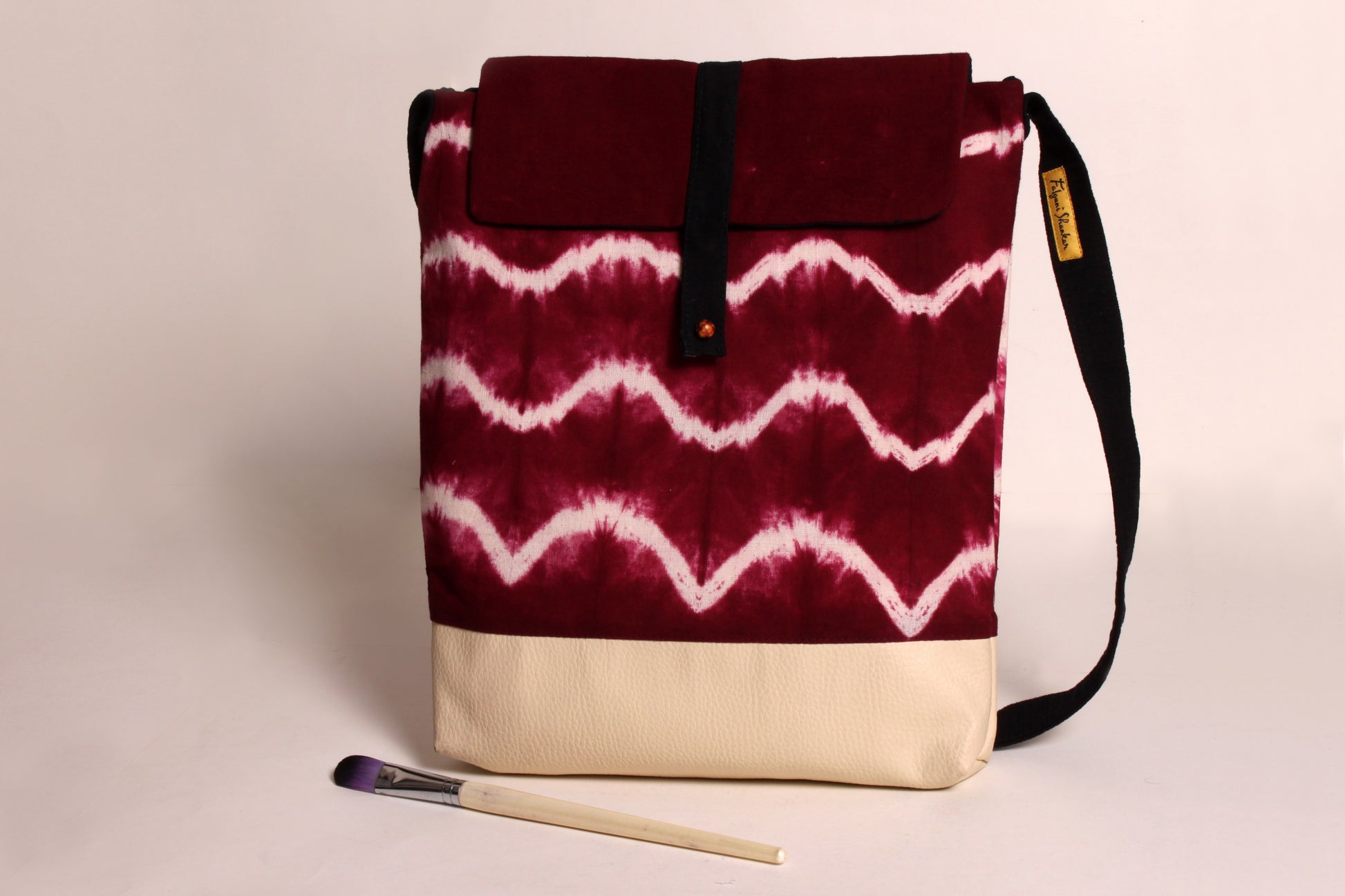 Front view of Maroon Wave Artist Bag made from cotton fabric with faux leather, a magnetic snap closure, and a pocket 