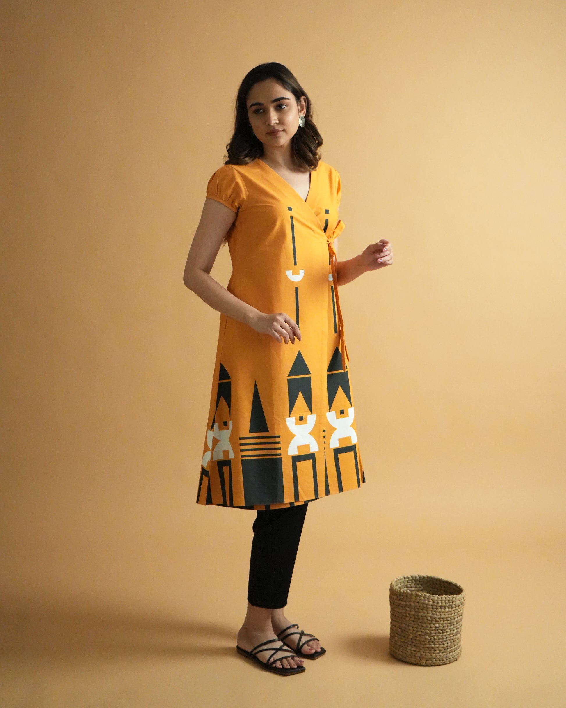 Side view of Kara Cotton Co-ord Set in vibrant orange with puff sleeves, tribal prints, and wrap kurta