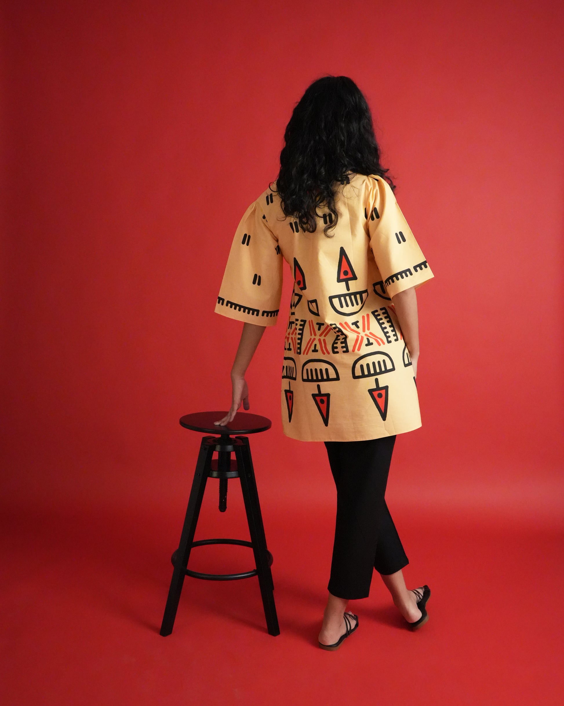 Back view of Owu Cotton Kurta Co-ord Set in pastel orange cotton showing tie detail and black pants