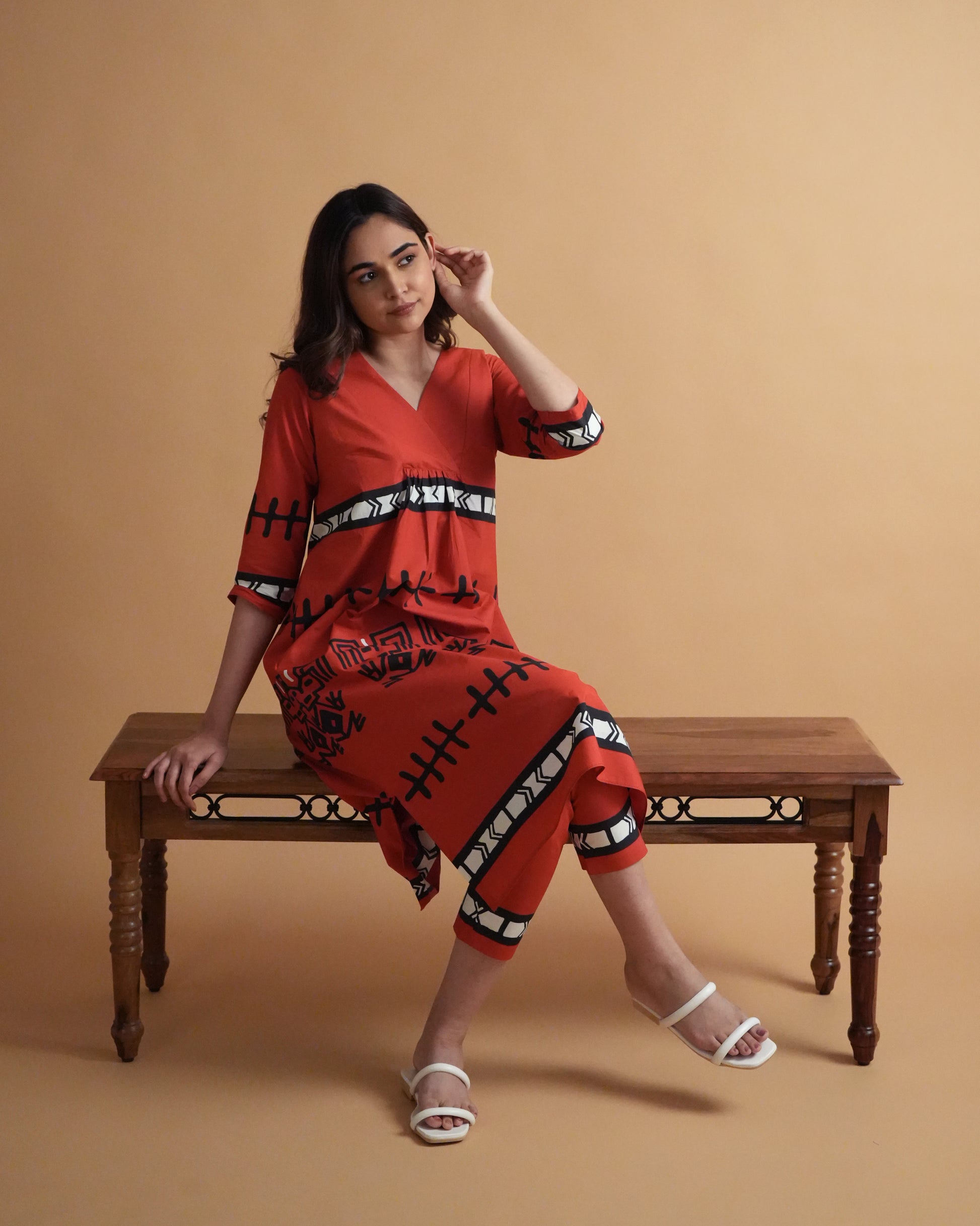Model wearing Puka Cotton Co-ord Set in vibrant red with tribal prints, side-slit kurta, and slim pants