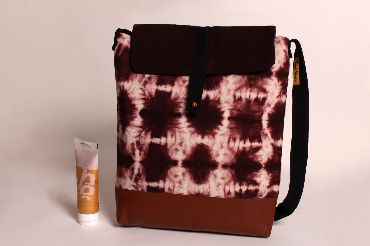 Front view of Brown Tile Artist Bag made from cotton fabric with faux leather, a magnetic snap closure, and a pocket 