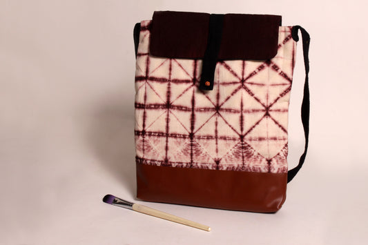 Front view of Brown  Tessellation Artist Bag made from cotton  with faux leather, a magnetic snap closure, and a pocket 