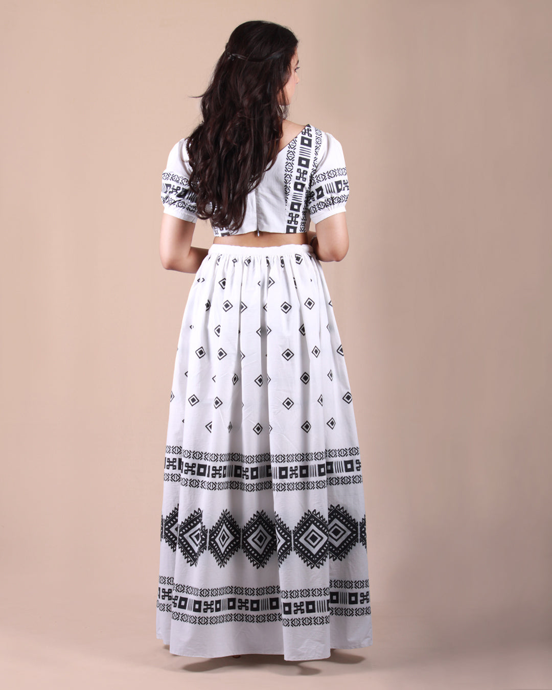 Back view of Ivory Tribal Co-ord Set with a cotton crop top and skirt with a tribal print, puff sleeves, and tassel details