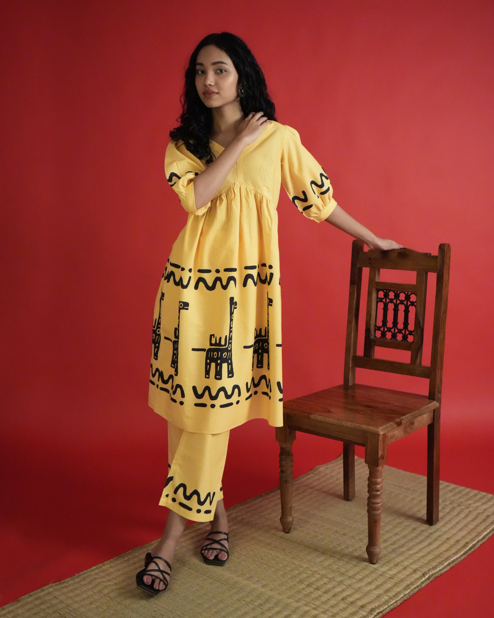 Front view of Sikwu Cotton Co-ord Set in mango yellow with puff sleeves, tribal prints, empire-line kurta, and wide-leg pants