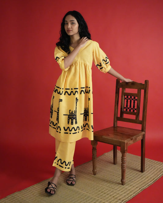 Front view of Sikwu Cotton Co-ord Set in mango yellow with puff sleeves, tribal prints, empire-line kurta, and wide-leg pants